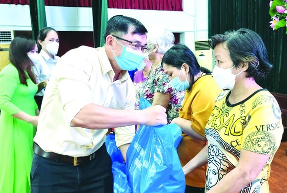 第五郡越南祖國陣線委員會副主席陳南德向貧困殘疾人士贈送禮物。