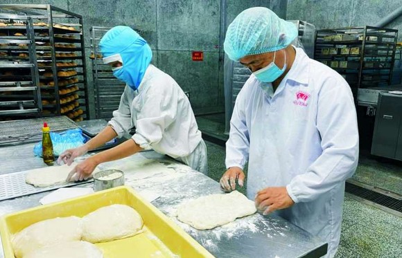 許玉林總經理（右）在製作餅乾，他希望 把台灣的美食推介給越南消費者。
