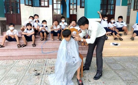黎友平校長免費給學生修剪頭髮。