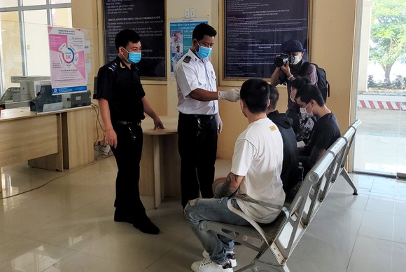 Lực lượng chức năng tỉnh An Giang kiểm tra sức khỏe cho các công dân vừa được phía Campuchia giải cứu và bàn giao. Ảnh: QUỐC BÌNH