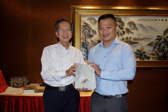 《西堤的見證》作者麒麟(右)代表贊助商向華文中心負責人贈書。