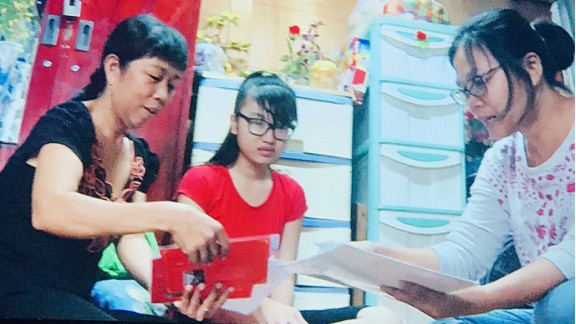 Em Lâm Huế Bình (giữa) được Hội Bảo vệ quyền trẻ em TPHCM  tặng sách vở, động viên đến trường