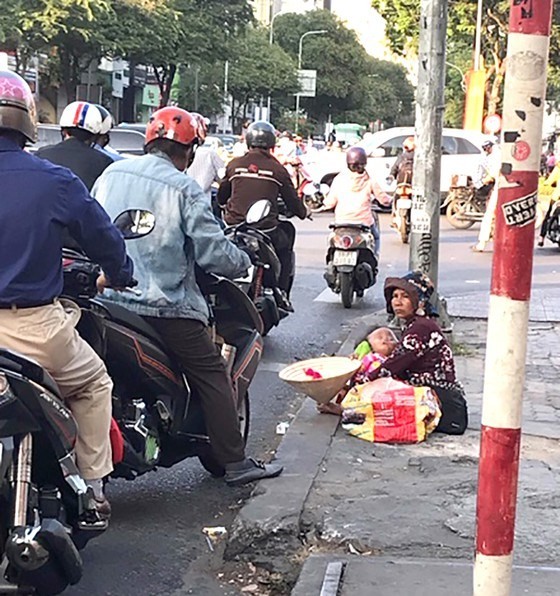 Beggars and the homeless on HCM City's main streets often fabricate stories about their personal circumstances. (Photo courtesy of sggp.org.vn)