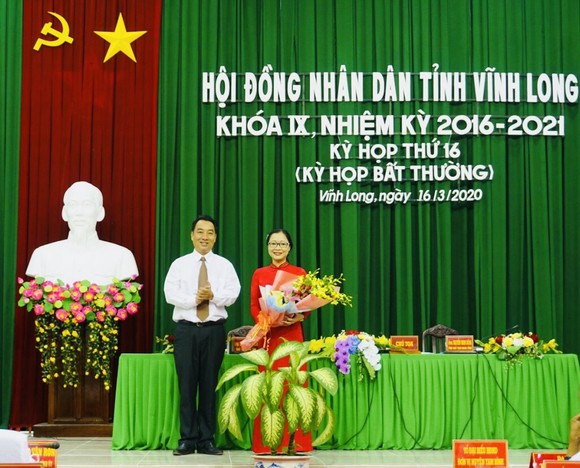 Chủ tịch UBND tỉnh Vĩnh Long (trái) trao hoa chúc mừng tân Phó Chủ tịch