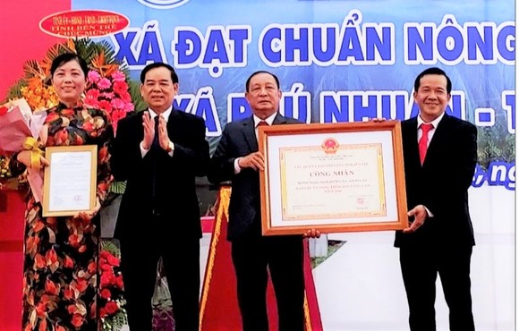 Chủ tịch UBND tỉnh Bến Tre Trần Ngọc Tam (bên trái, thứ 2) trao bằng công nhận xã nông thôn mới nâng cao cho lãnh đạo xã Phú Nhuận
