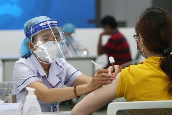 HCMC strives for over 90 percent of population to get third Covid vaccine booster shot ảnh 1
