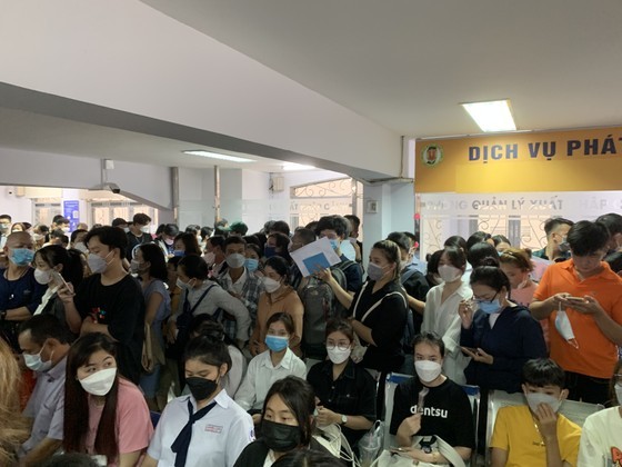 People in HCMC wait in long queues at passport office on July 1 ảnh 2