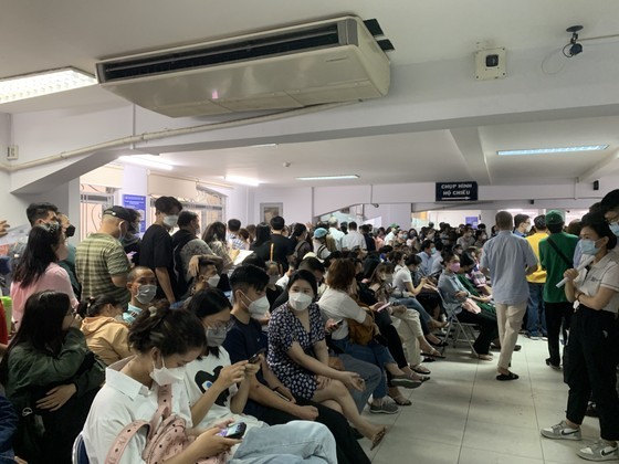 People in HCMC wait in long queues at passport office on July 1 ảnh 3